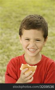 Portrait of a boy holding a burger
