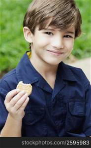 Portrait of a boy holding a cookie and smiling