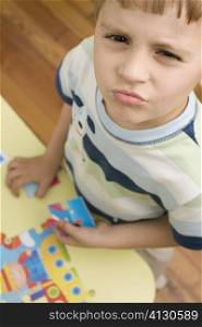 Portrait of a boy holding a puzzle piece