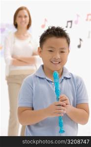 Portrait of a boy holding a recorder flute and smiling