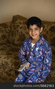 Portrait of a boy holding a remote