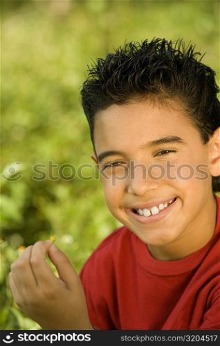 Portrait of a boy holding a wildflower