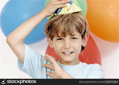Portrait of a boy holding party hat on his head