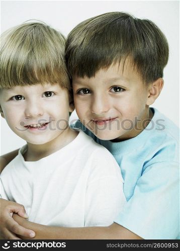 Portrait of a boy hugging his brother from behind
