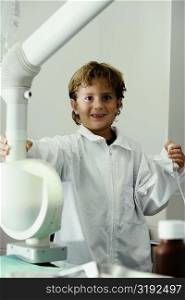 Portrait of a boy imitating a doctor and operating an X-Ray machine
