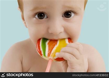 Portrait of a boy licking a lollipop