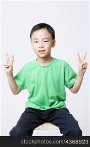 Portrait of a boy making a peace sign