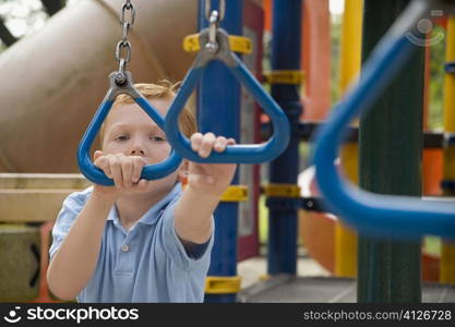 Portrait of a boy playing on monkey bars