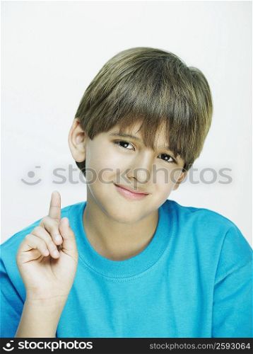 Portrait of a boy pointing upwards