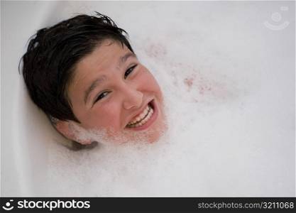 Portrait of a boy smiling in a bubble bath