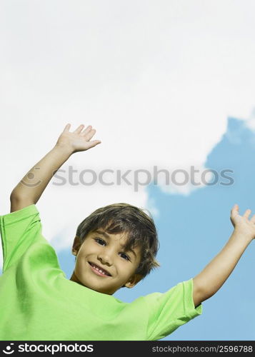 Portrait of a boy smiling with his arms raised