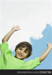Portrait of a boy smiling with his arms raised