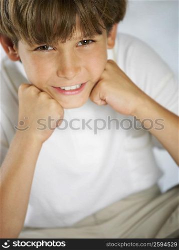 Portrait of a boy smiling with his hand on his chin