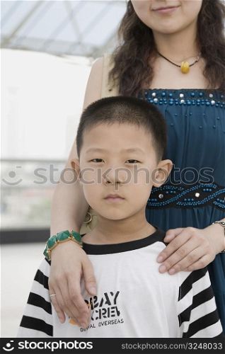 Portrait of a boy standing with his mother