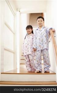 Portrait of a boy standing with his sister near a staircase
