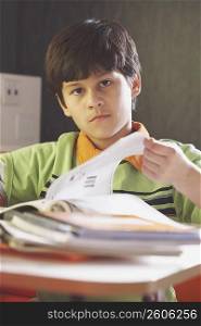 Portrait of a boy turning page of a textbook
