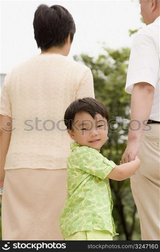 Portrait of a boy walking with his grandparents