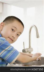Portrait of a boy washing his hands in a wash basin