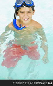 Portrait of a boy with a scuba mask on his head in a swimming pool