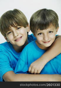 Portrait of a boy with his arm over his brother