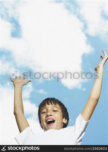 Portrait of a boy with his arms raised