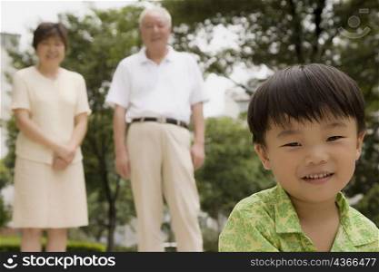 Portrait of a boy with his grandparents standing behind him