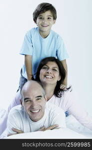 Portrait of a boy with his parents on the bed