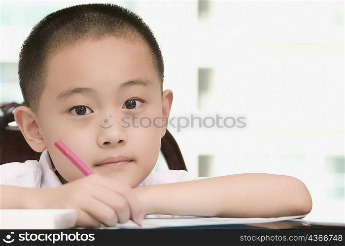 Portrait of a boy writing on a sheet of paper