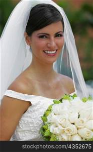 Portrait of a bride holding a bouquet of flowers and smiling