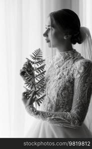 portrait of a bride in the morning before the wedding with putting on a white dress