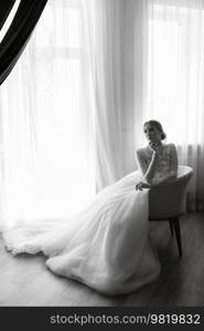 portrait of a bride in the morning before the wedding with putting on a white dress