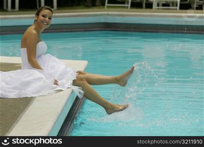 Portrait of a bride sitting a the poolside and smiling