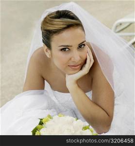 Portrait of a bride sitting with her hand on her chin