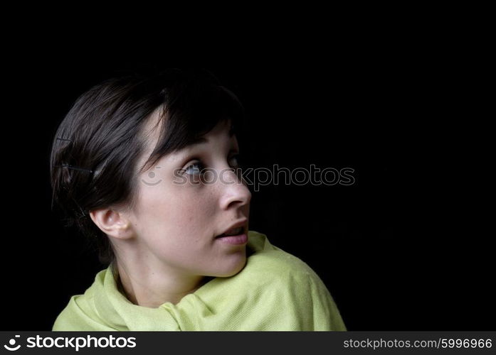 Portrait of a brunette young girl in black background