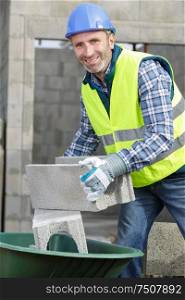 portrait of a builder working with concrete blocks