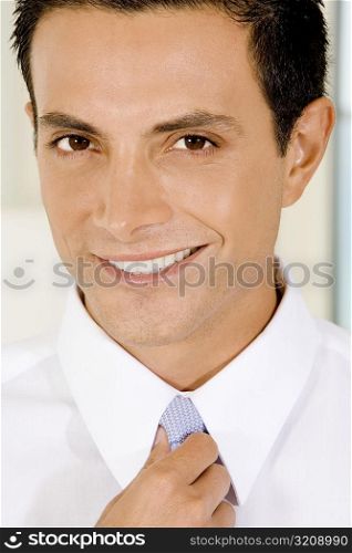 Portrait of a businessman adjusting his tie
