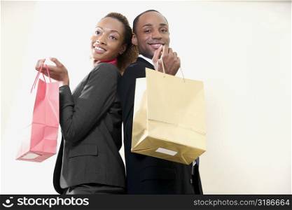 Portrait of a businessman and a businesswoman holding shopping bags