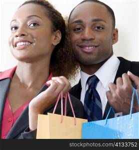 Portrait of a businessman and a businesswoman holding shopping bags
