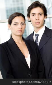 Portrait of a businessman and a businesswoman standing together in front of a window