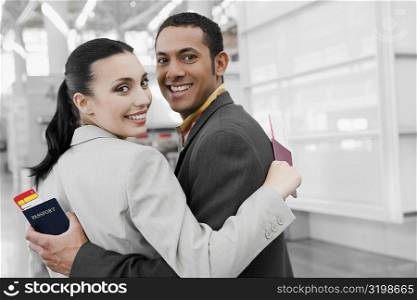 Portrait of a businessman and a businesswoman with their arms around each other and smiling