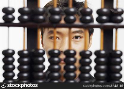 Portrait of a businessman behind an abacus