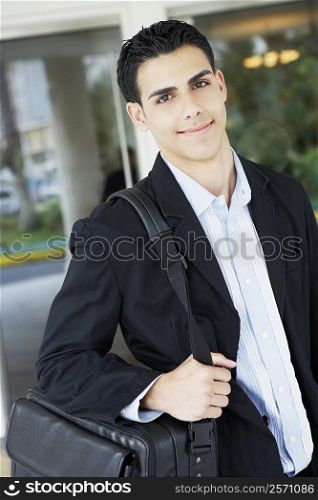 Portrait of a businessman carrying a bag and smiling