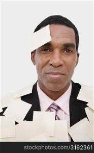 Portrait of a businessman covering with adhesive notes and smiling