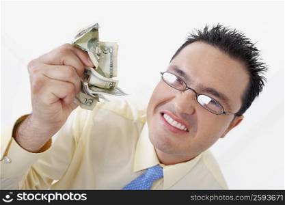 Portrait of a businessman crushing five dollar bills