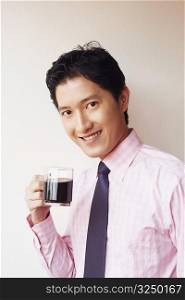 Portrait of a businessman drinking a cup of black tea and smiling