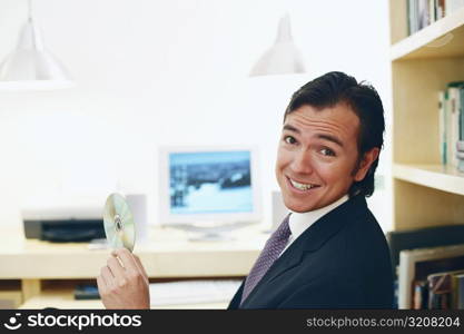 Portrait of a businessman holding a CD