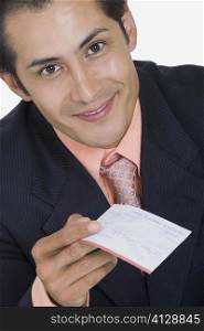Portrait of a businessman holding a check and smiling
