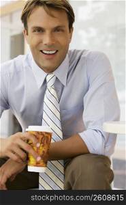 Portrait of a businessman holding a coffee cup and smiling