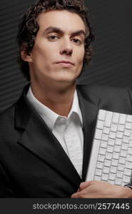 Portrait of a businessman holding a computer keyboard