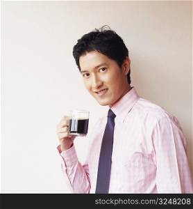 Portrait of a businessman holding a cup of black tea and smiling